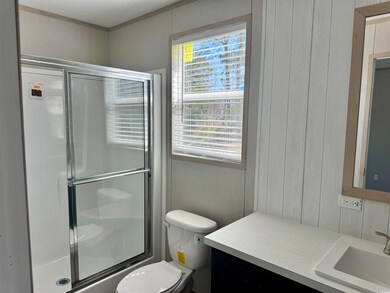 Full bath featuring toilet, vanity, and a shower w