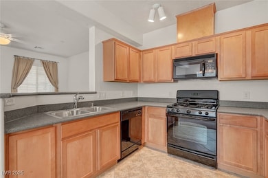 Kitchen featuring black appliances, light brown cabinets, and light tile patterned flooring