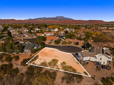Aerial view of residential area with a mountainous background and property boundaries highlighted