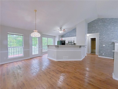 Unfurnished living room featuring a ceiling fan, v