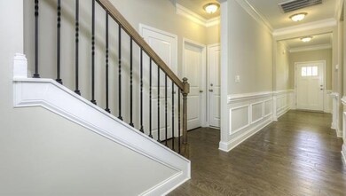Staircase at end of Foyer across from Kitchen. Powder Room & Drop zone.  All photos of a similar home.