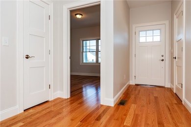 Entry Hallway with Hardwood floors and closet to t