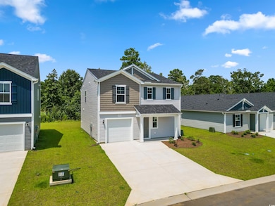 View of front of property featuring a garage and a front yard