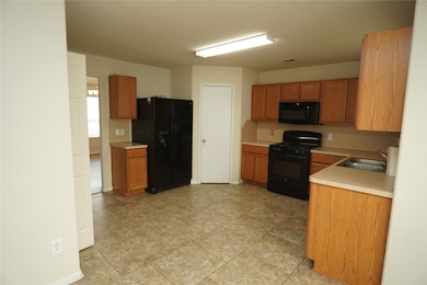 This kitchen features tiled flooring, ample wooden