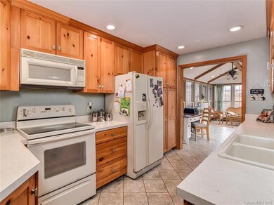 Wood cabinets and open to sun room over looking po