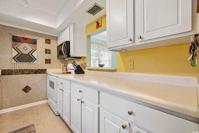 Kitchen featuring visible vents, tile walls, light