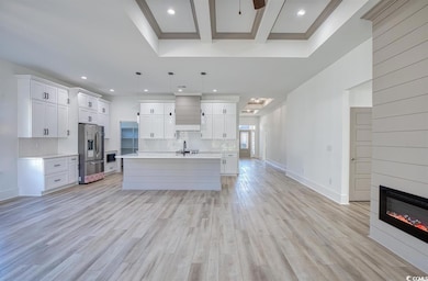 Kitchen with light countertops, backsplash, stainless steel appliances, white cabinetry, and recessed lighting