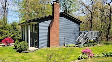 View of home's exterior featuring a wooden deck and a yard