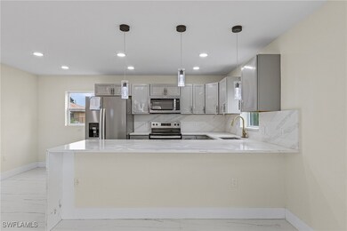 Kitchen with gray cabinets, appliances with stainl