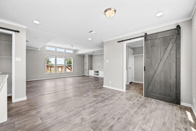 Unfurnished living room with crown molding, a barn