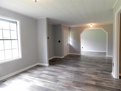 Natural lighting is abundant in this formal dining room/living room. The room just beyond the archway is ideal for a study or library.