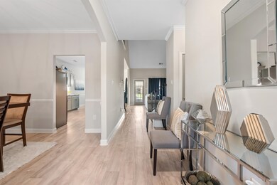 Corridor featuring crown molding and light hardwoo