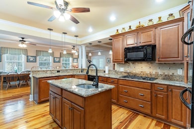 Kitchen with black appliances, an island with sink