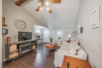 Living room featuring beamed ceiling, ceiling fan,