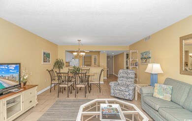 Living area with light tile patterned floors, a textured ceiling, and a chandelier