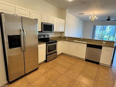 Kitchen with stainless steel appliances, white cabinetry, ceiling fan, a peninsula, and light tile patterned floors