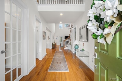Foyer entrance featuring a high ceiling and hardwo