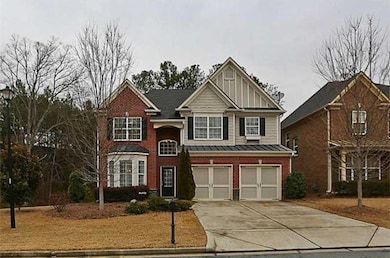 View of front of property with driveway, an attached garage, brick siding, board and batten siding, and a standing seam roof
