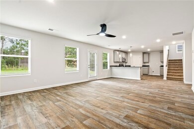 Unfurnished living room featuring stairway, light wood-type flooring, recessed lighting, and ceiling fan