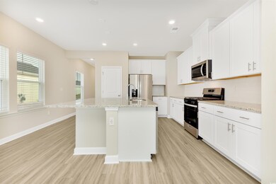 Kitchen with a kitchen island with sink, baseboard