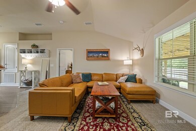 Living room featuring ceiling fan, hardwood / wood-style flooring, and vaulted ceiling