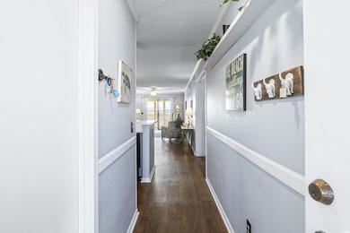 Hallway with a textured ceiling and dark wood-type