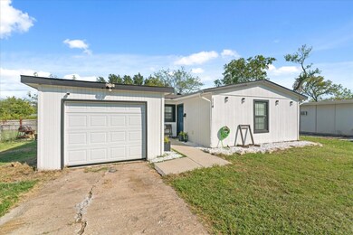 Ranch-style house featuring a garage and a front y