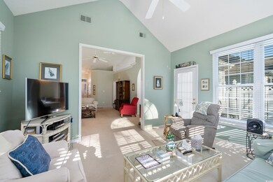 Carpeted living room featuring ceiling fan and hig
