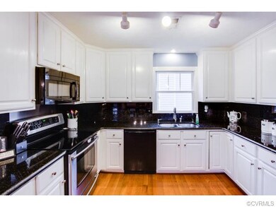 The dark granite counter tops and white cabinets c