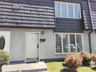 Property entrance with stucco siding and mansard roof