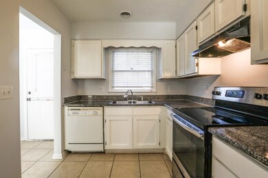 Kitchen featuring electric stove, white cabinets, 