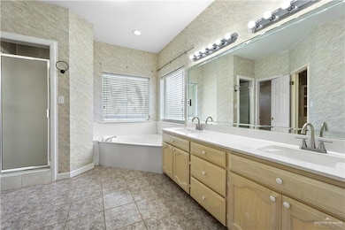 Full bath featuring double vanity, a stall shower, a bath, and tile patterned floors