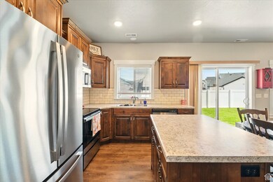 Kitchen with appliances with stainless steel finishes, dark wood finished floors, backsplash, light countertops, and recessed lighting