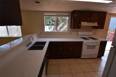 Kitchen featuring dark brown cabinets, appliances
