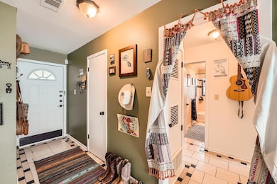 Foyer featuring light tile patterned floors and b