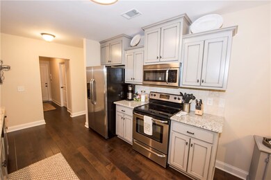 Kitchen with custom painted cabinetry, granite cou