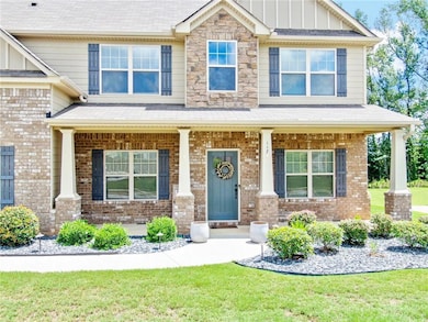 View of front of house featuring a porch, board and batten siding, brick siding, a front yard, and a shingled roof