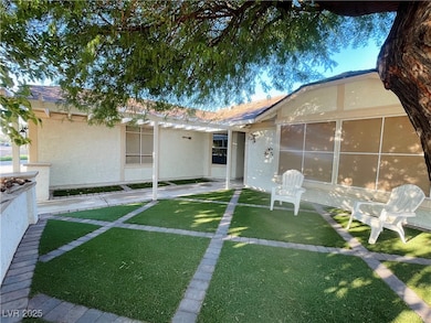 Rear view of property with stucco siding, a yard, and a patio area