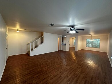 Unfurnished living room with stairway, dark wood 