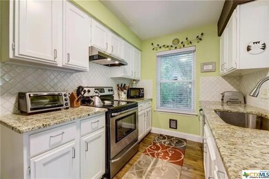 Kitchen featuring electric stove, white cabinets, decorative backsplash, and dark wood-style floors