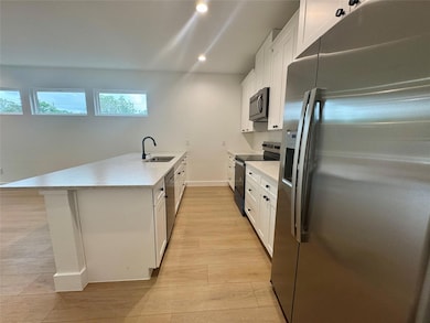 Kitchen featuring stainless steel appliances, lig