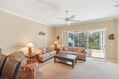 Living area featuring light colored carpet, ceiling fan, ornamental molding, and baseboards