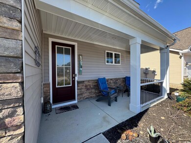 Property entrance with stone siding and covered po