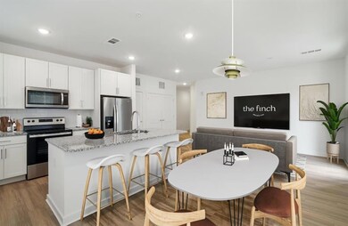 Kitchen featuring a kitchen island with sink, stai