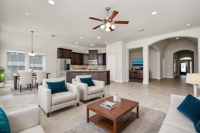 This open-concept layout provides a seamless transition from the living area to the kitchen, ideal for modern living. The dark wood cabinetry and stainless-steel appliances add a touch of luxury to the heart of the home.