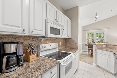 Kitchen featuring white cabinets, lofted ceiling, 