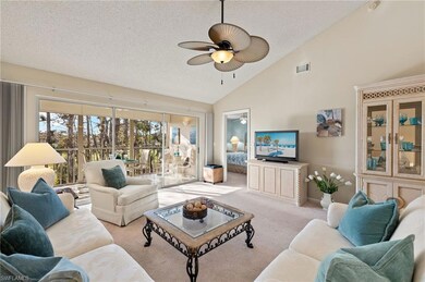 Living room with high vaulted ceiling, light carpe