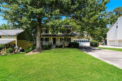 View of front of home with a porch, driveway, and a front yard