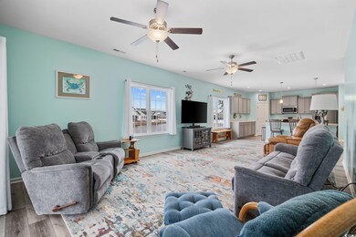 Living room with ceiling fan and light hardwood / 