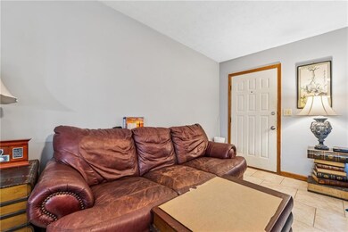 807 Charleston - Living room with vaulted ceiling, light tile patterned flooring, and baseboards